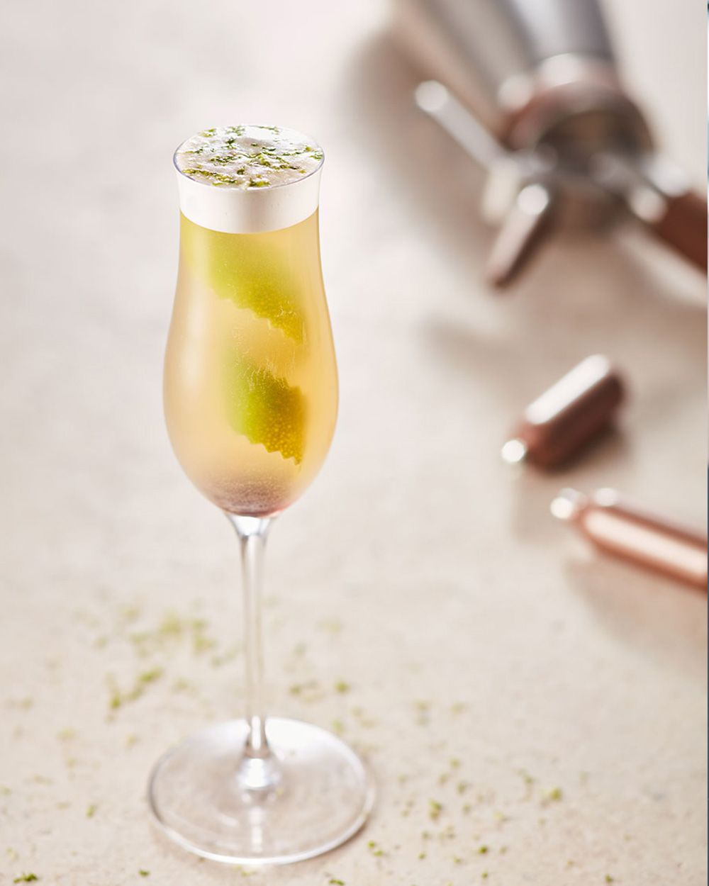 Ein Glas mit Nitro Kombucha Quitte, daneben iSi Charge Kapseln und ein iSI Gourmet Whip.