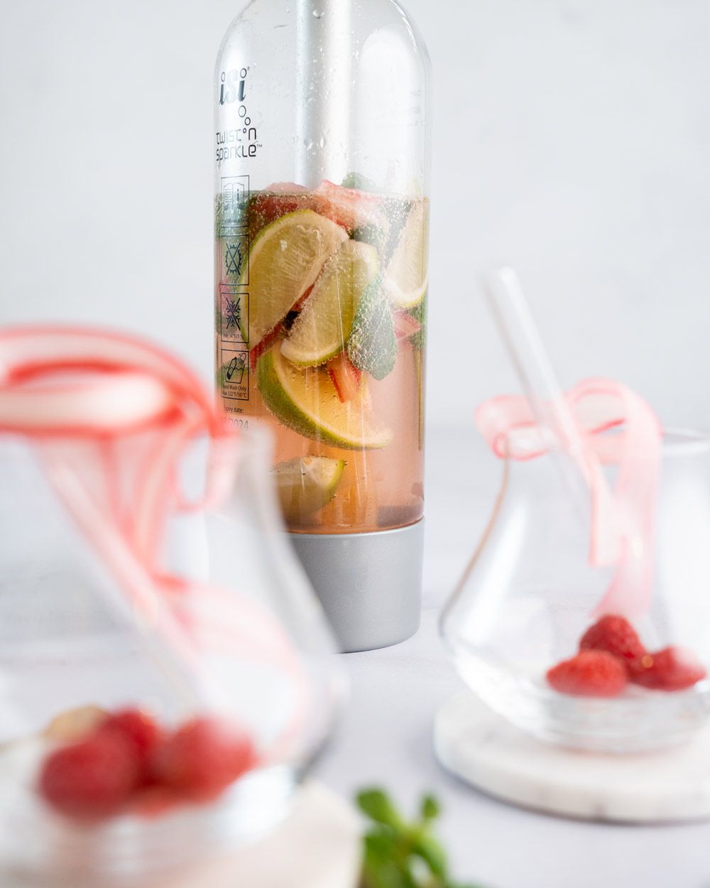 Zwei leere Gläser, daneben ein iSi Soda Maker, gefüllt mit Virgin Rhabarber Mojito.