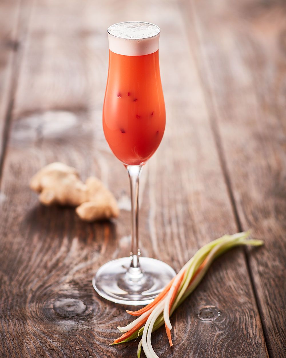 Ein Glas mit Nitro Carrot Gingertini, daneben Ingwer. 