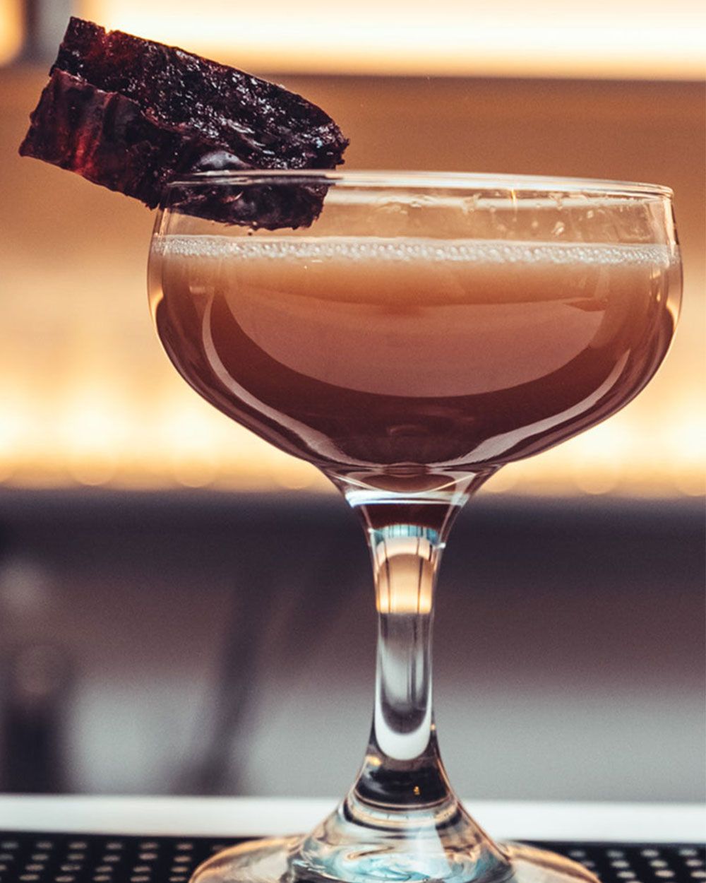 Ein Glas mit einem dunklen Getränk. 