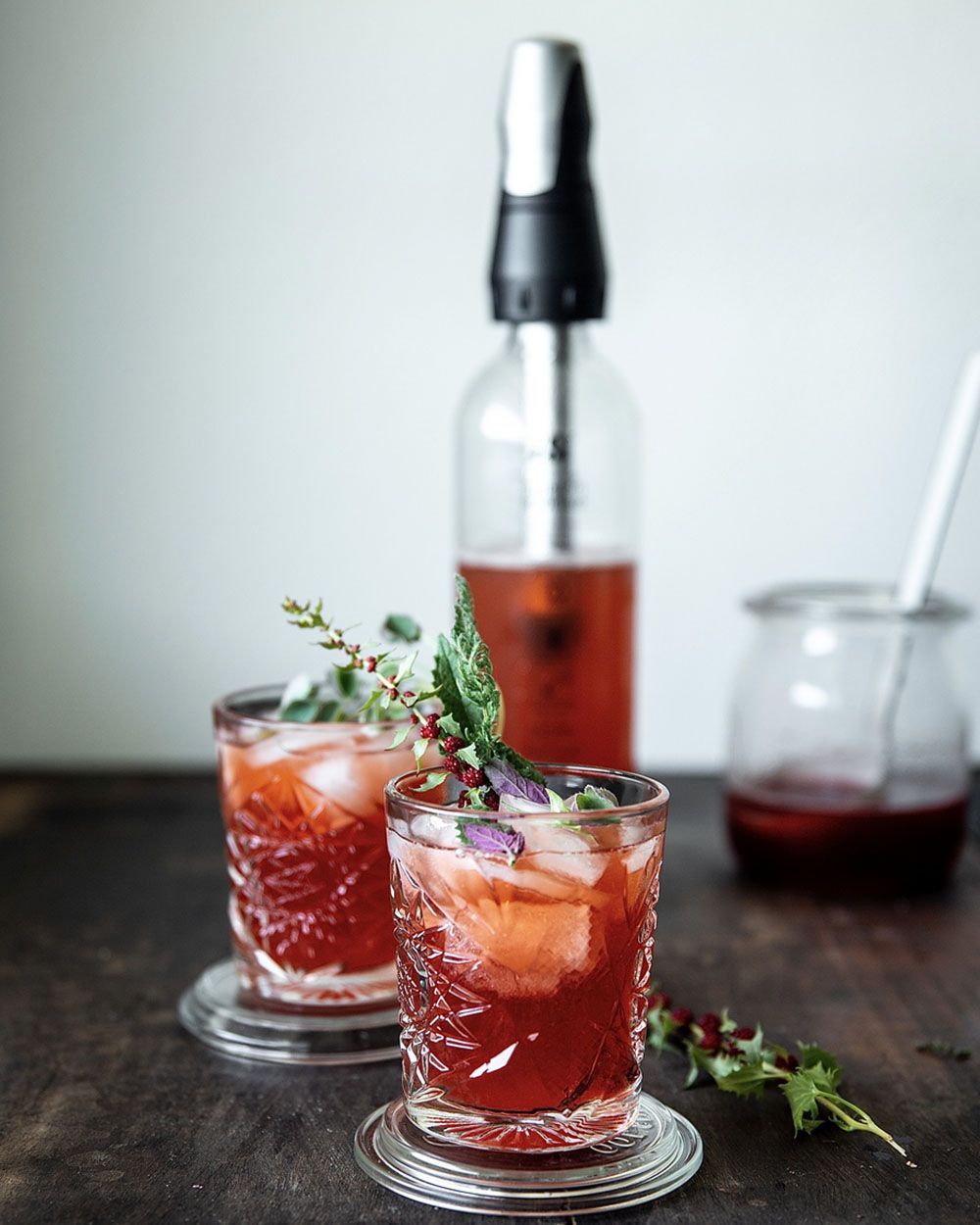Zwei Gläser mit roten Getränken, Strawberry Shrub mit Vanille. Im Hintergrund ein iSi Soda Maker. 