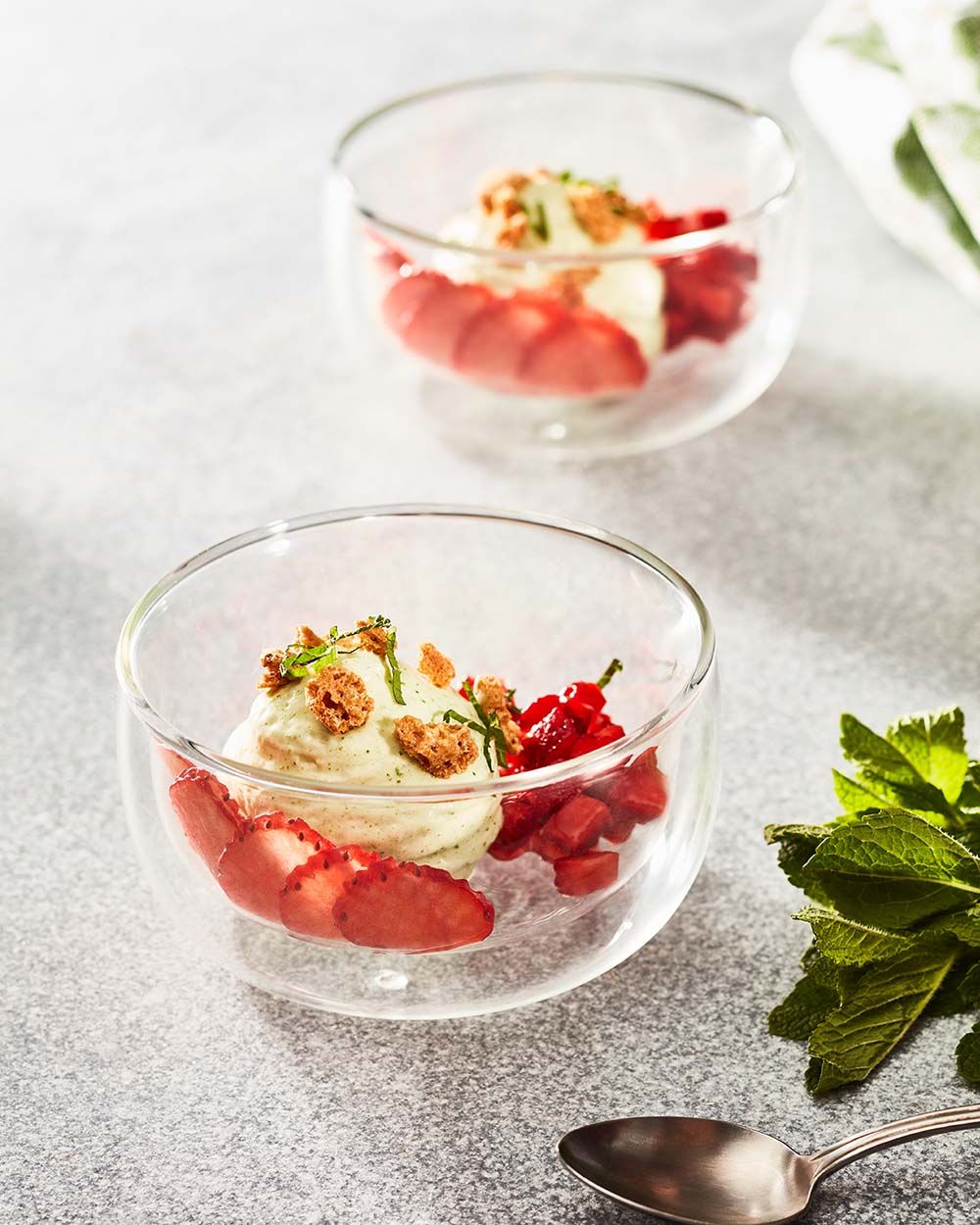 Zwei Schüsseln mit Sauerampfer-Schaum und Erdbeeren. 