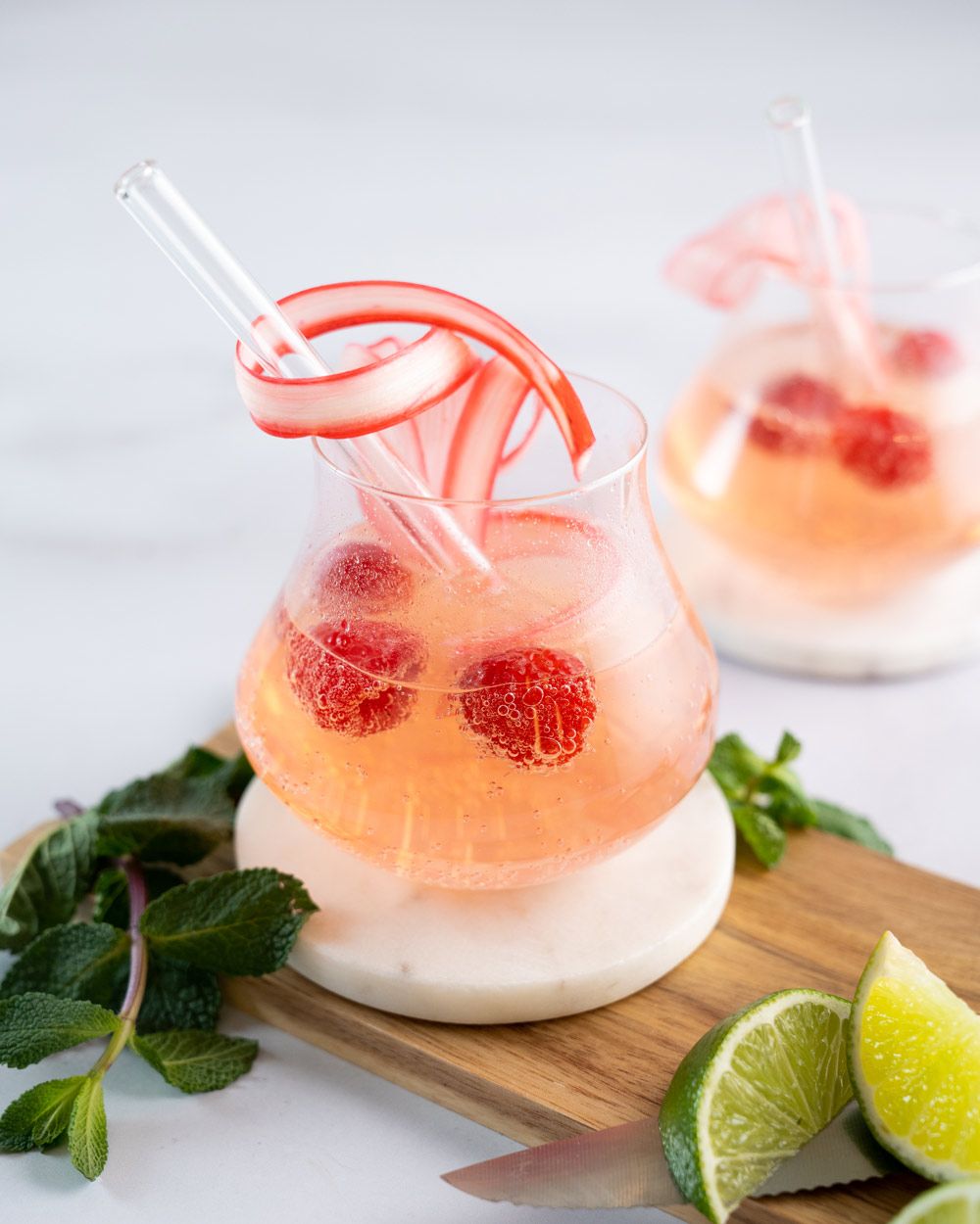 Zwei Gläser mit einem rosa Getränk, ein Virgin Rhabarber Mojito. 