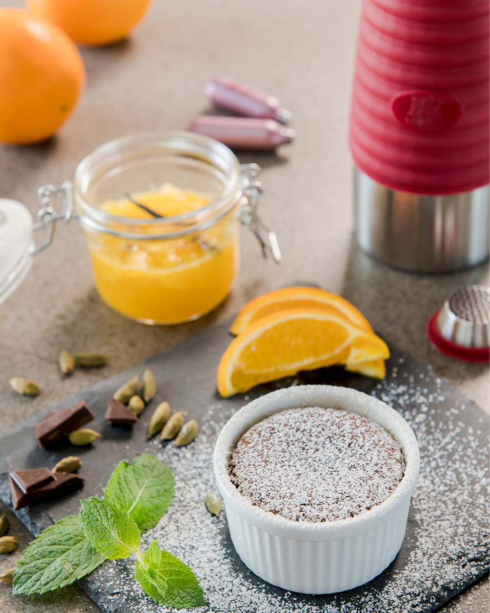 Eine Schale mit Schokokuchen, daneben Orangen und ein Glas mit Orangensalat. Im Hintergrund ein iSi Gourmet Whip und zwei iSi Charge Kapseln. 