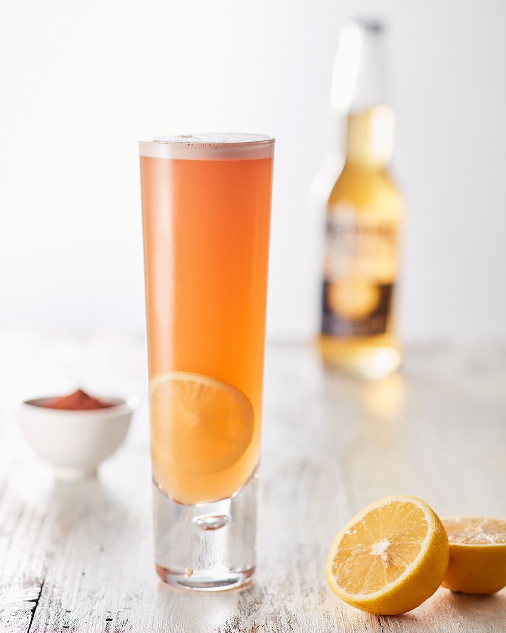 Ein Glas mit Nitro Chocolate Beer, daneben Zitronen und im Hintergrund eine Flasche Corona. 