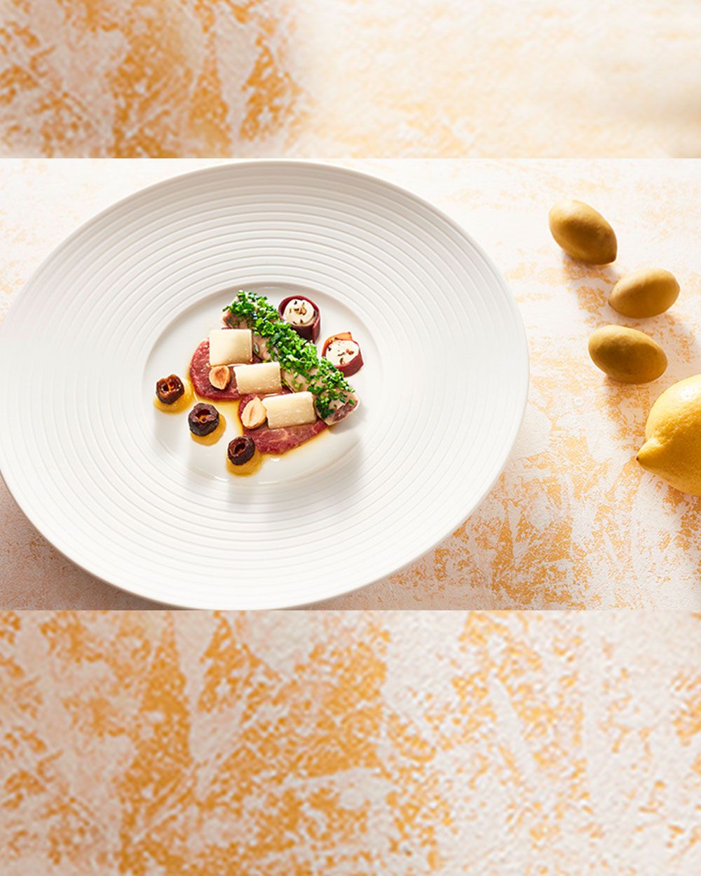 Ein Teller mit Carpaccio und Oliven. 