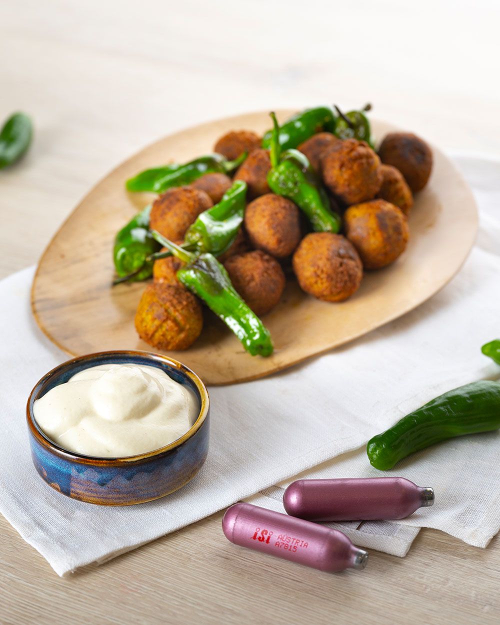 Ein Teller mit Falafeln und Jalapenos, daneben eine Schüssel mit Aioli Sauce und iSi Charge Kapseln. 