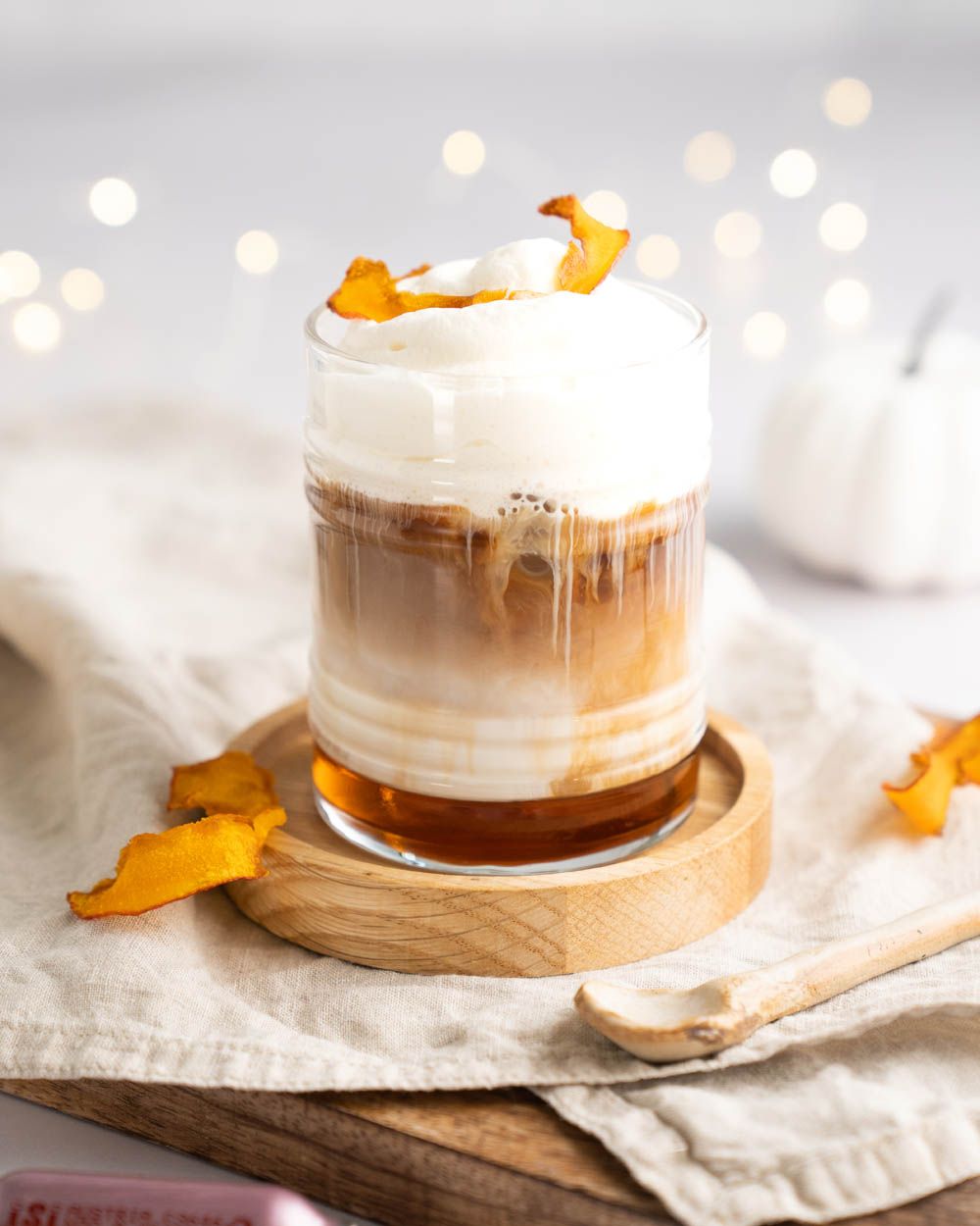 Ein Glas mit einem Kaffeegetränk mit Kürbisschaum-Topping.