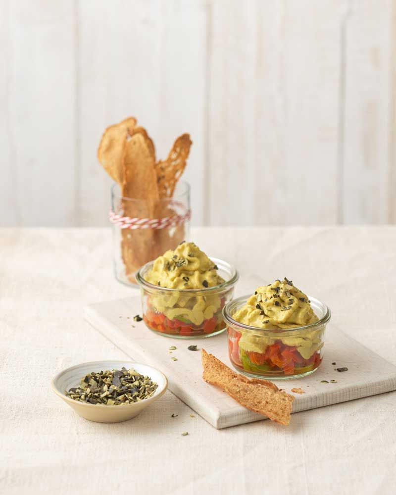 Zwei Schalen mit Linsen-Espuma, daneben eine Schale mit Gewürzen und im Hintergrund ein Glas mit Brot-Sticks.