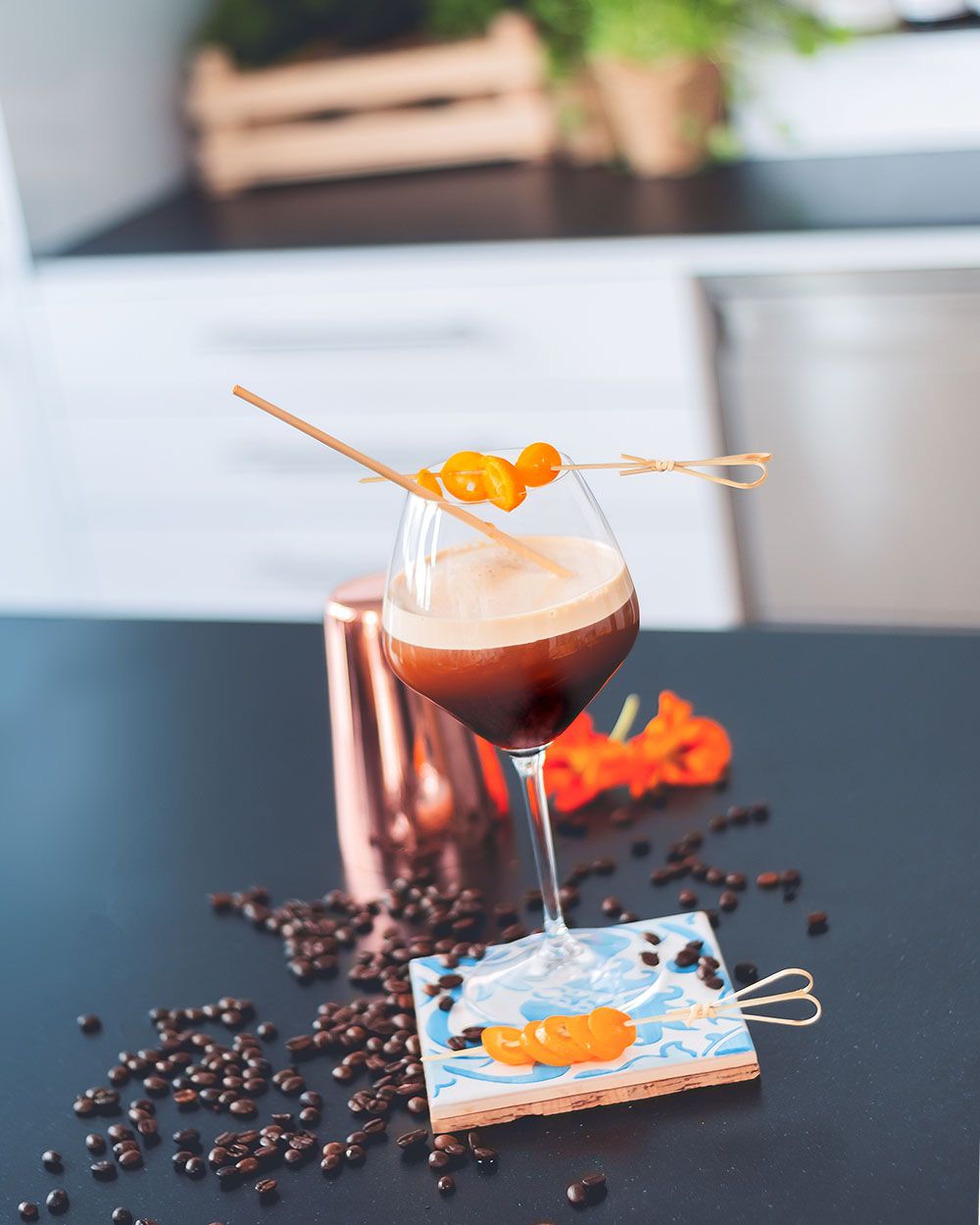 Ein Glas mit Nitro Sangria, daneben Kaffeebohnen. 