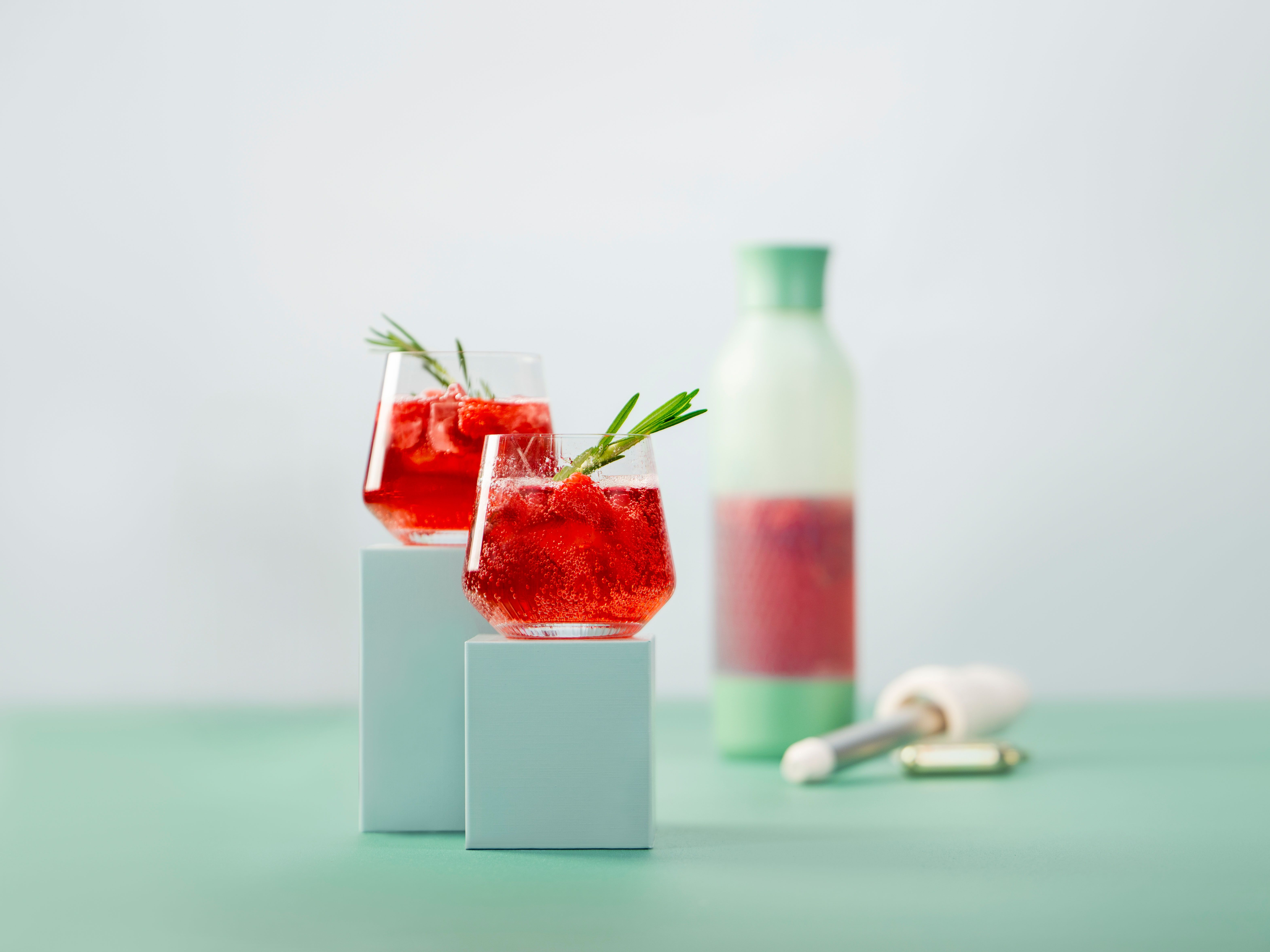 Zwei Gläser mit Raspberry Shrub, daneben ein iSi Twist'n Sparkle und iSi Charge Kapseln.