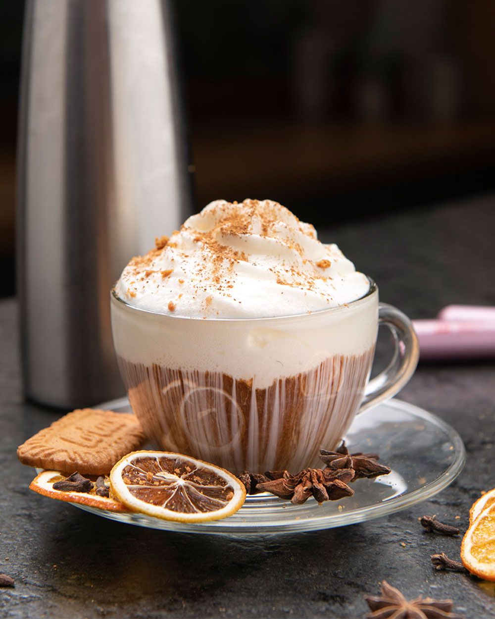 Ein New York Cheesecake Cappuccino, mit Nelken, Lotuskeksen und getrockneten Orangen. 