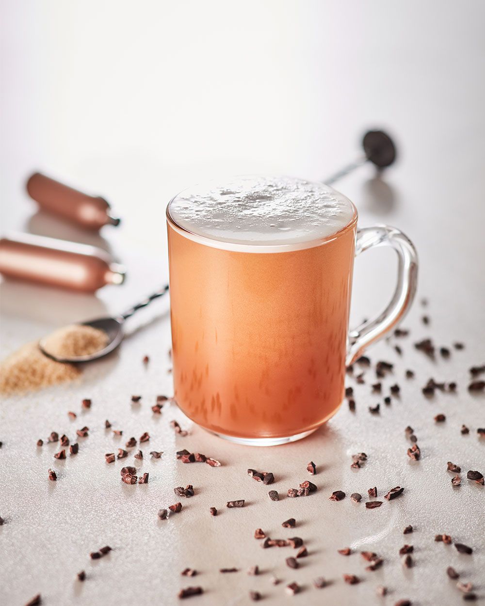 Ein Glas mit Nitro Chocolate Rum, daneben Gewürze und iSi Charge Kapseln. 