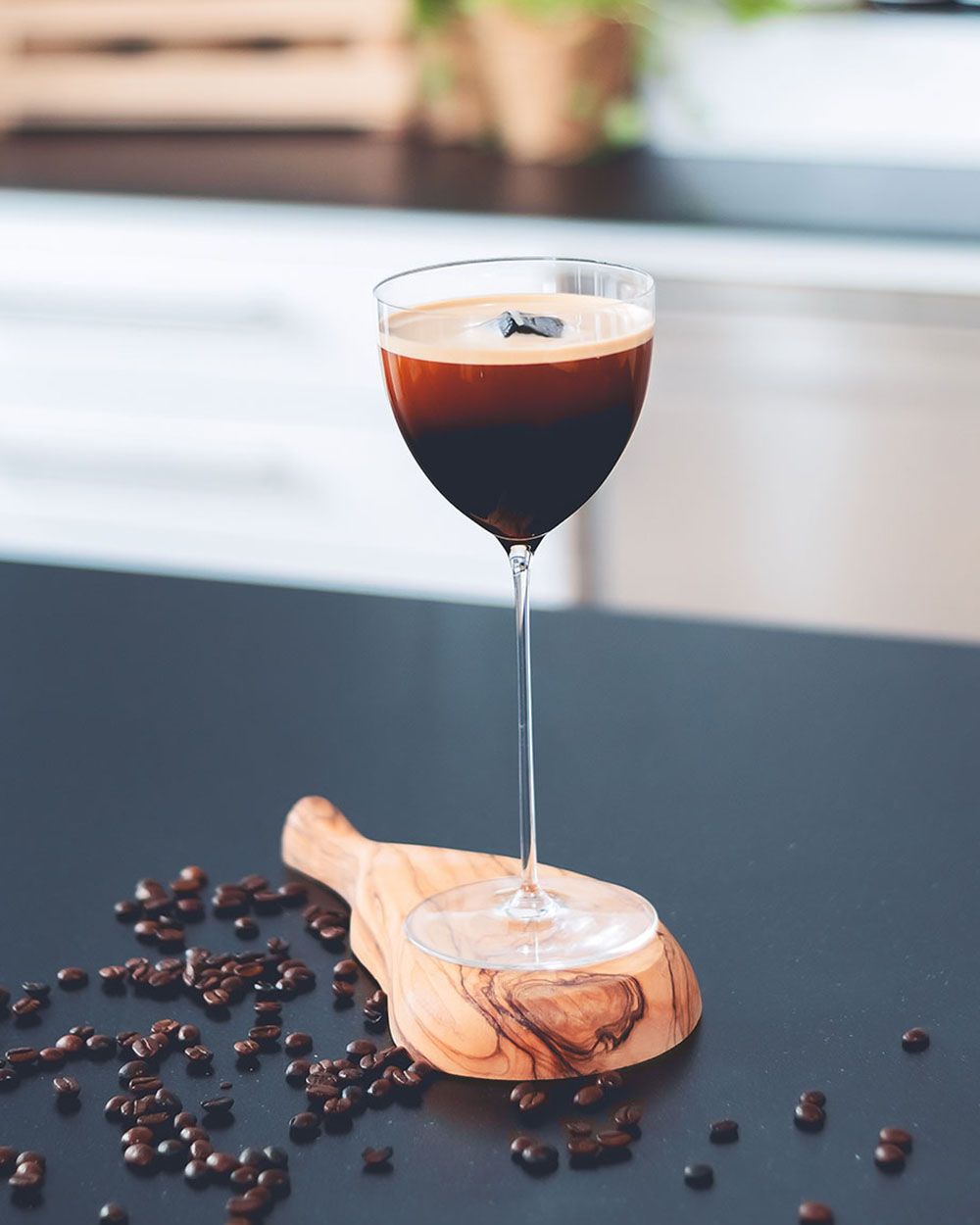 Ein Glas mit Nitro Martini, daneben Kaffeebohnen. 